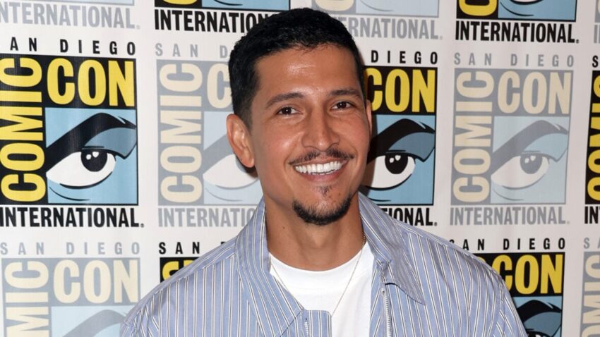 Danny Ramirez smiles while posing at Comic-Con