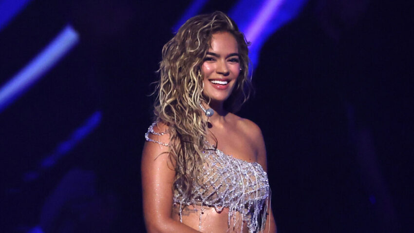 Karol G smiles on stage at American Music Awards